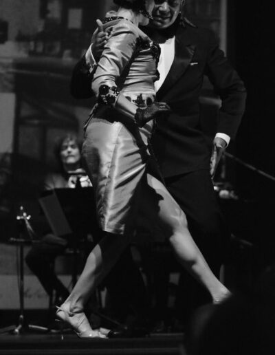 Black and white photograph of a tango couple dancing on stage by Justine Pistorius